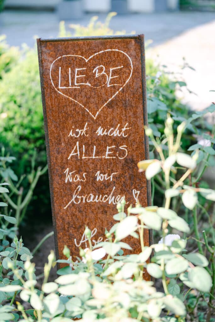 SCHLOSSHOCHZEIT IN VASOLDSBERG. mit zitat auf rosttafel im garten vom schloss vasoldsberg – detailaufnahme von diehochzeitsfotografen