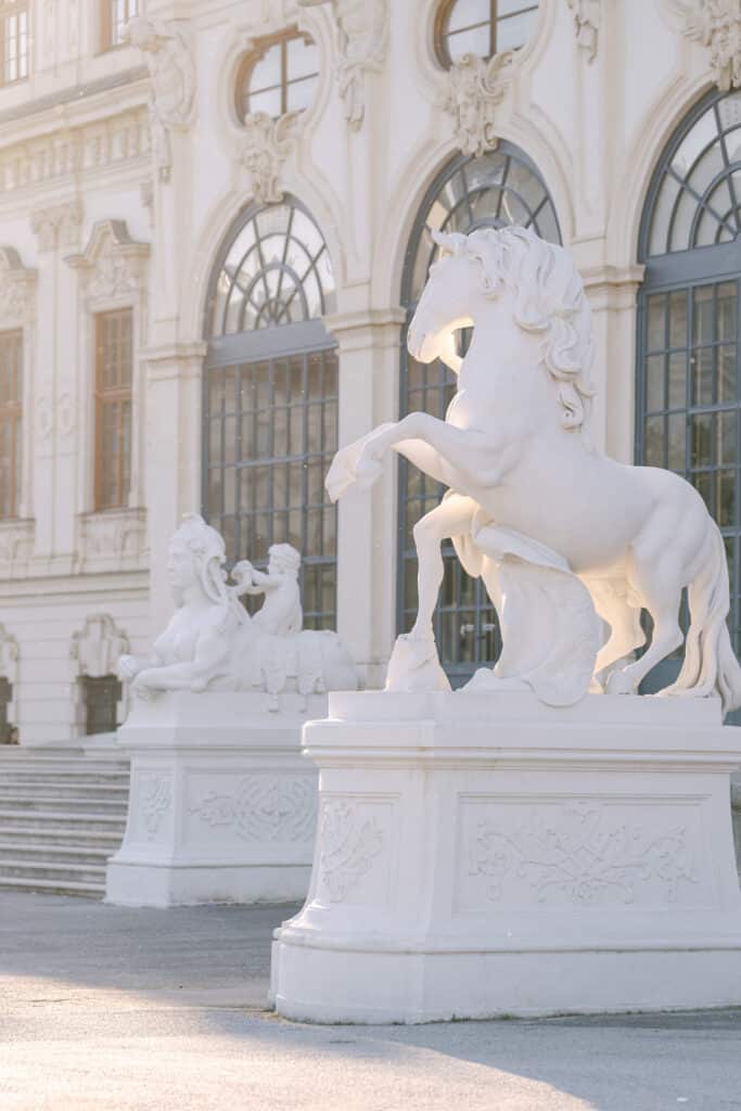 VERLOBUNGSSHOOTING IM SCHLOSS BELVEDERE Weiße Pferdeskulptur vor dem Schloss Belvedere in Wien