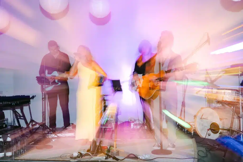 Live-Band mit Sängerin im bunten Bühnenlicht mit Bewegungsunschärfe, Hochzeitsparty in der Orangerie im Schlosspark Eisenstadt