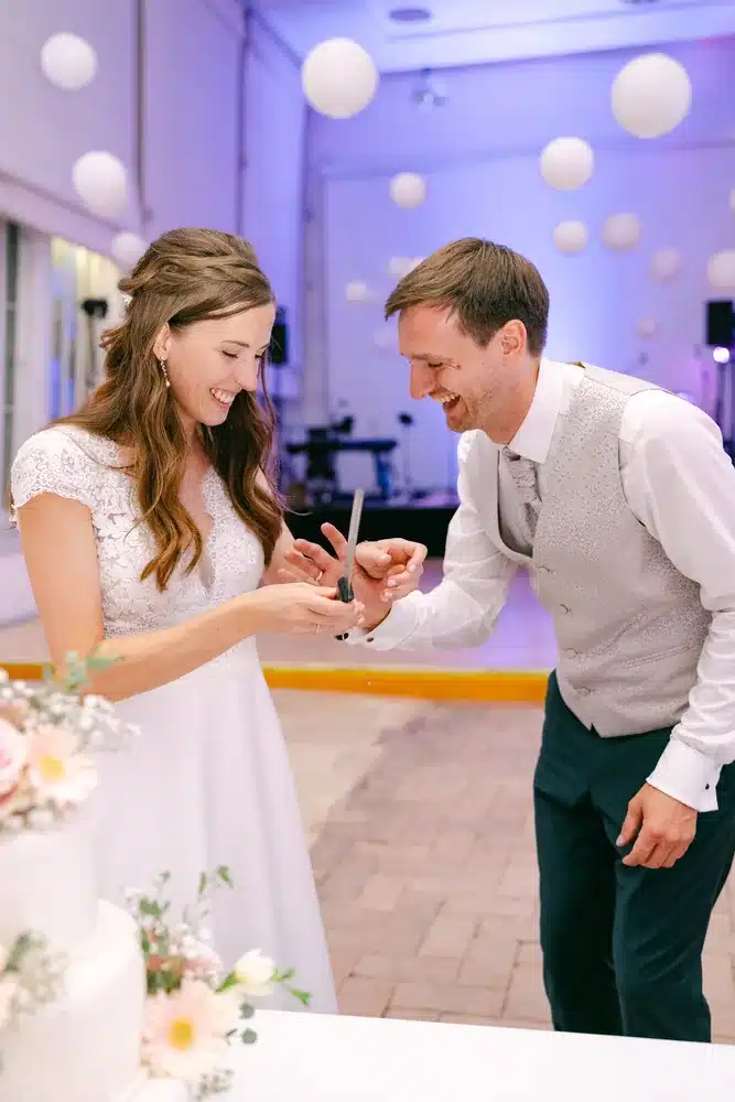 Brautpaar probiert lachend das erste Stück der Hochzeitstorte im Festsaal der Orangerie im Schlosspark Eisenstadt