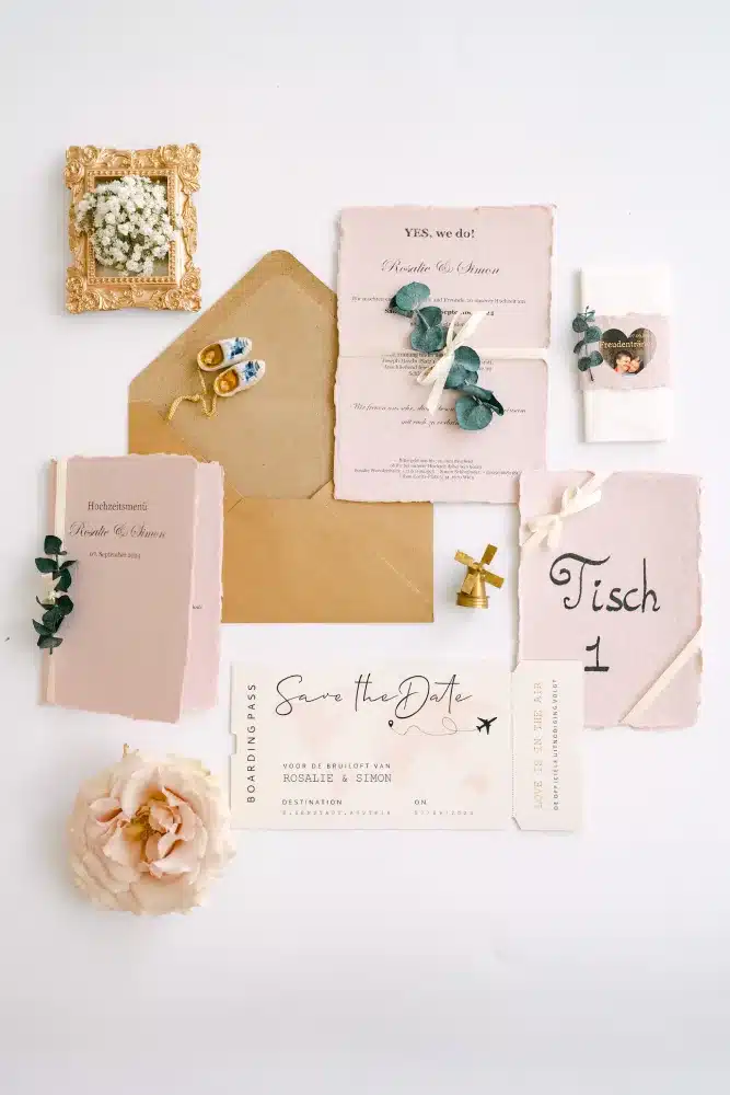 Hochzeitspapeterie mit Einladungen, Kuvert, Tischkarte und Save-the-Date-Karte, fotografiert am Hochzeitstag in der Orangerie im Schlosspark Eisenstadt