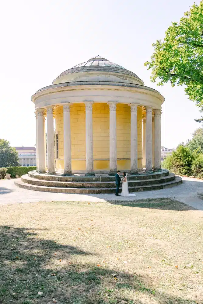 Runder gelber Säulentempel im Schlosspark Eisenstadt, davor das Brautpaar klein im Bild, Heiraten in der Orangerie im Schlosspark Eisenstadt
