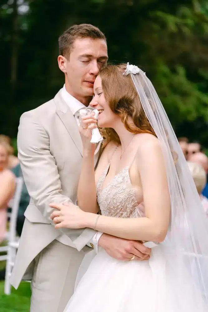 Heiraten in der Hochzeitslocation Schloss Margarethen am Moos – Trauung: Bräutigam küsst die weinende Braut nach dem Jawort
