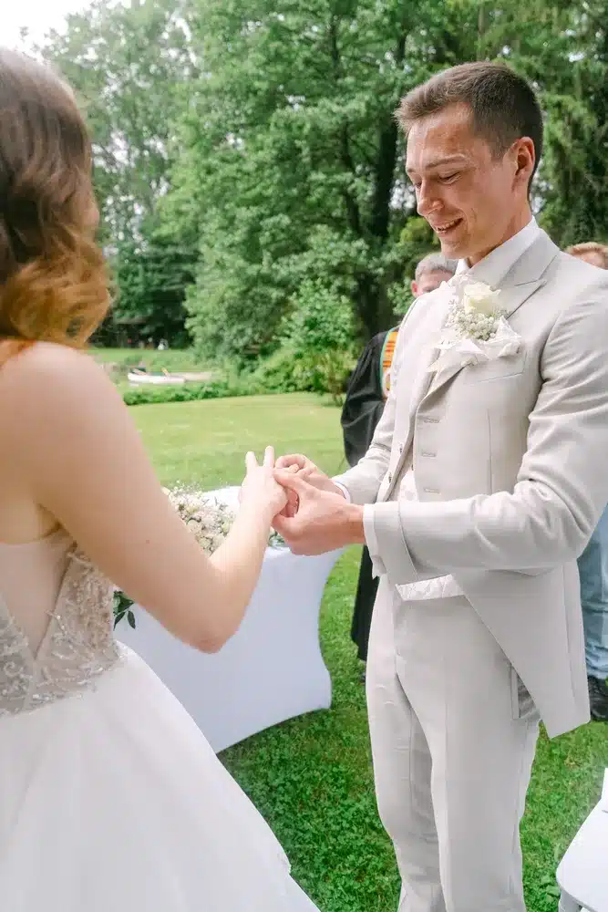 Heiraten in der Hochzeitslocation Schloss Margarethen am Moos – Trauung: Bräutigam streift der Braut den Ehering über