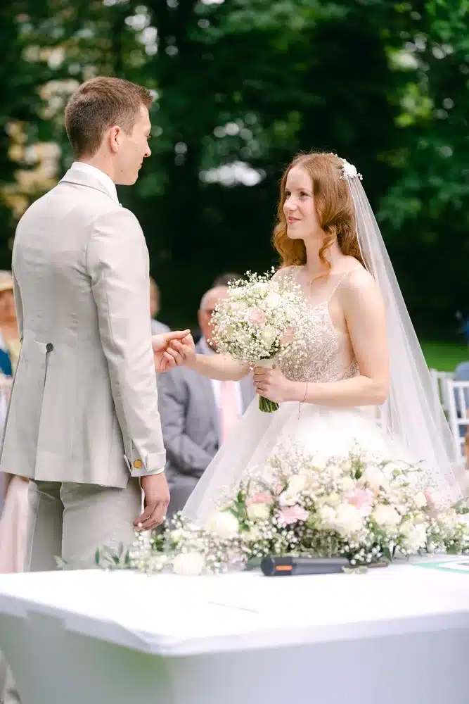 Heiraten in der Hochzeitslocation Schloss Margarethen am Moos – Trauung: Braut lächelt den Bräutigam während der Zeremonie an