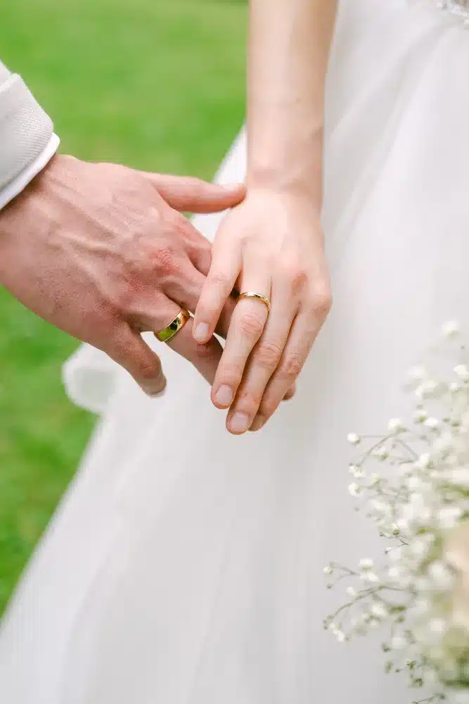 Heiraten in der Hochzeitslocation Schloss Margarethen am Moos – Details und Vorbereitungen: Brautkleid hängt am Fenster neben Schuhen und Brautstrauß