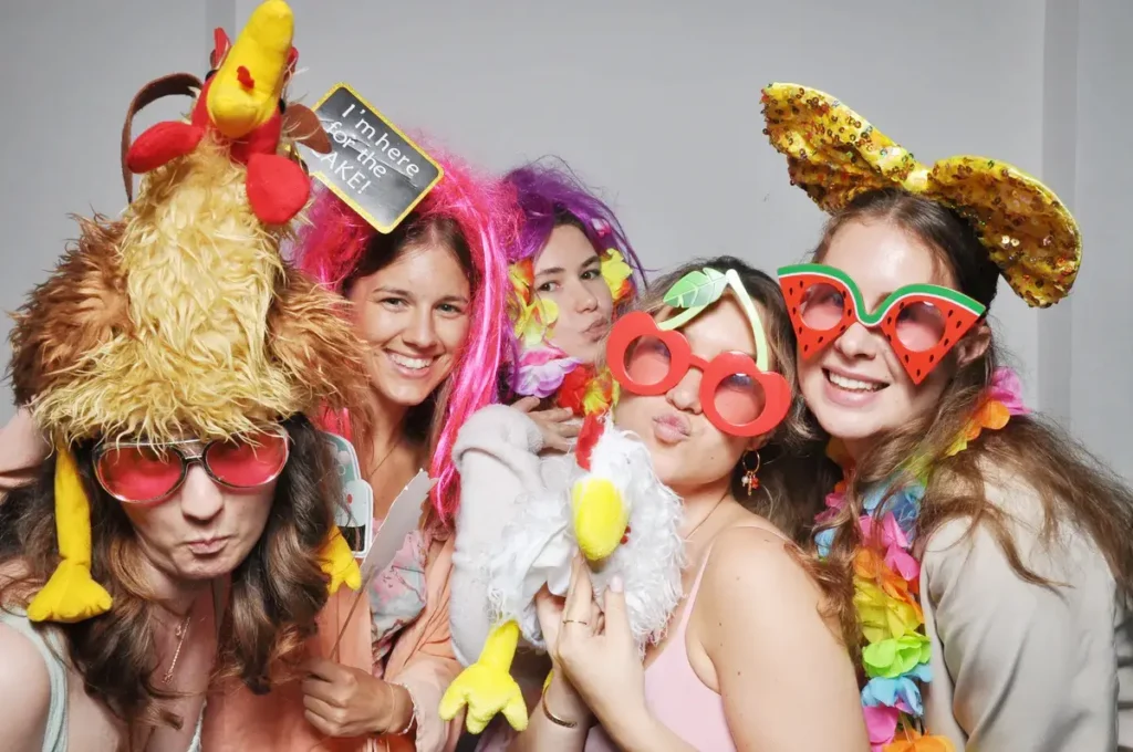 Heiraten in der Hochzeitslocation Schloss Margarethen am Moos – Feier, Hochzeitstanz und Party: Fünf Frauen mit bunten Partybrillen an der Fotobox