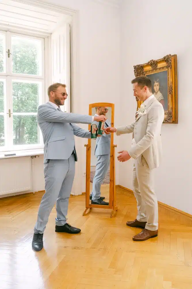 Heiraten in der Hochzeitslocation Schloss Margarethen am Moos – Feier, Hochzeitstanz und Party: Zwei Männer stoßen scherzhaft mit Dosen an