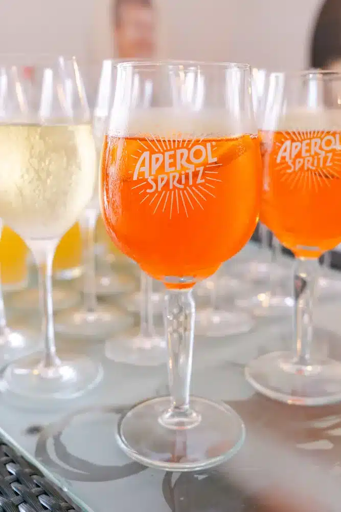 Gläser mit Aperol Spritz und Sekt stehen bereit