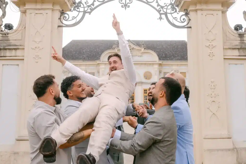 Bräutigam wird von seinen Freunden vor dem Schlosstor in die Luft geworfen
