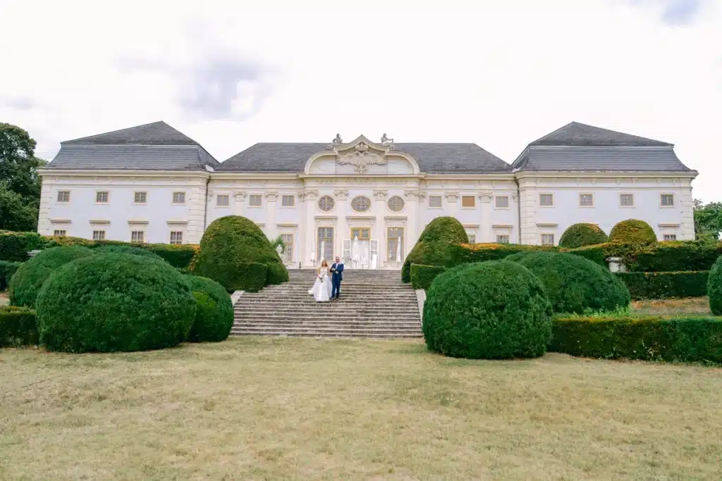 Braut und Begleiter kommen die Freitreppe von Schloss Halbturn herunter