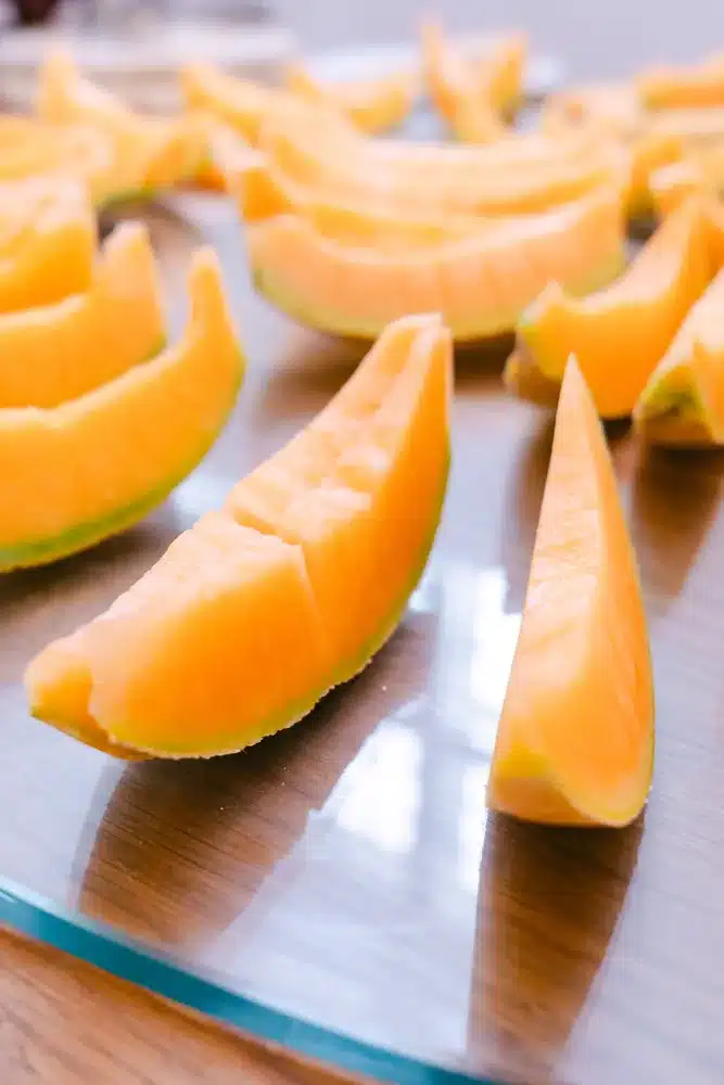 Aufgeschnittene Melonenspalten auf einem Holzbrett